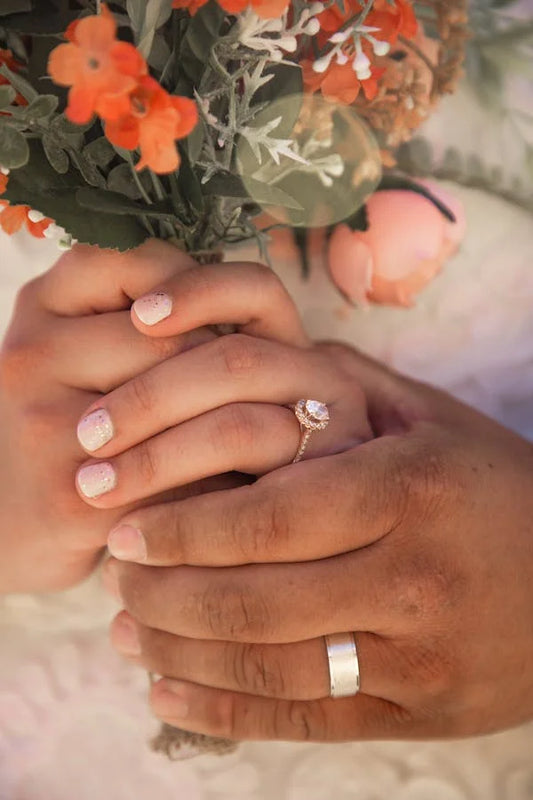 Married Couple holding bouquet in hands showing their wedding rings