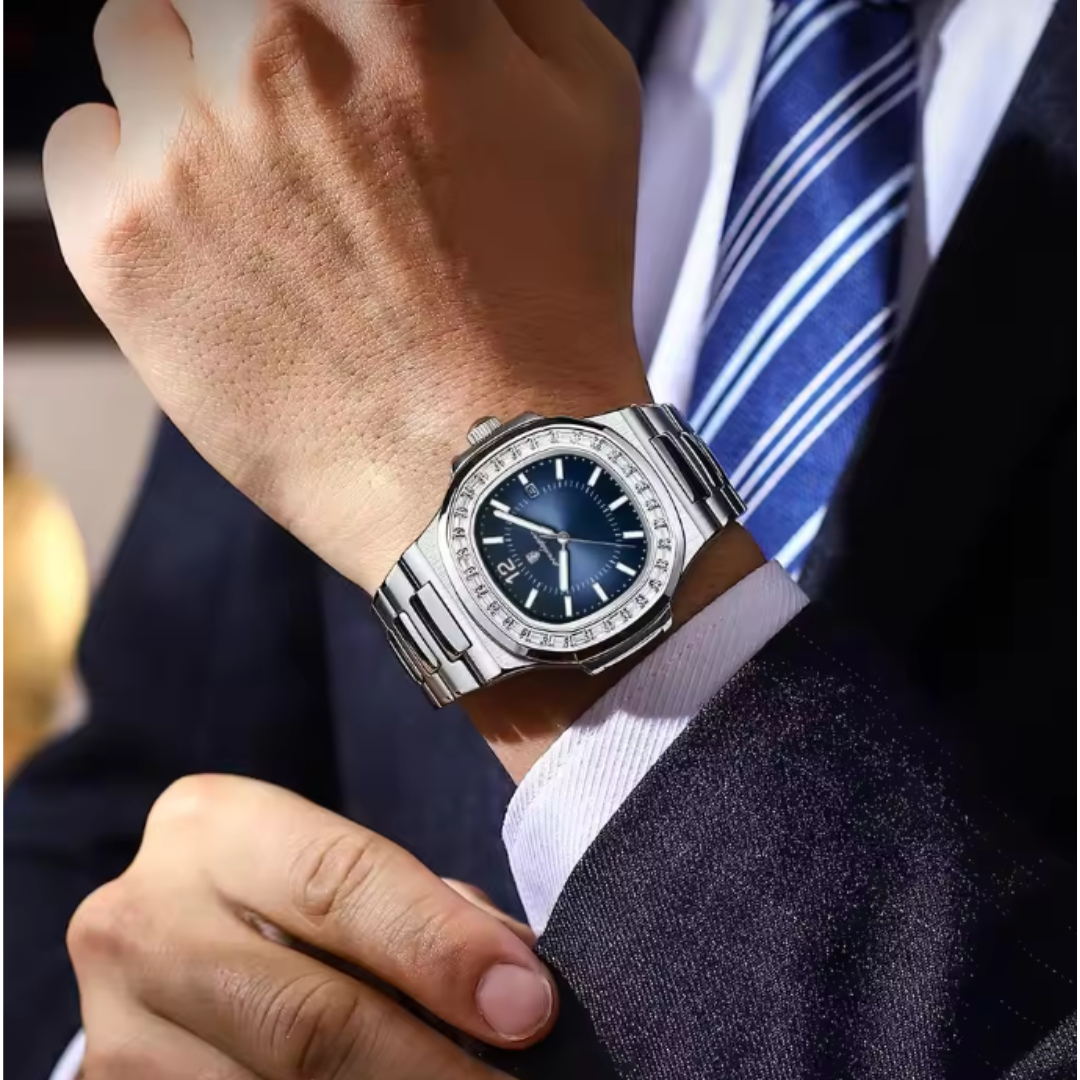 Close-up of a person wearing a Boujee Ice silver watch with a blue face, dressed in formal attire.